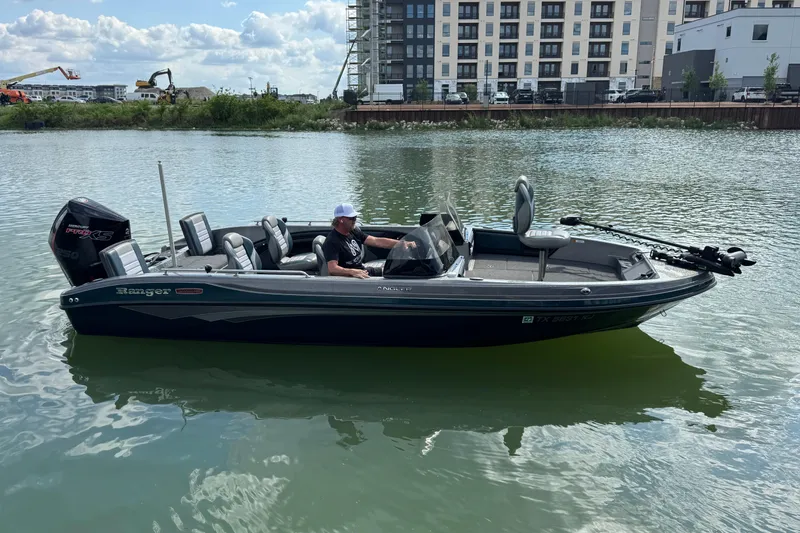 Slide: The Image of 2020 Ranger 2080MS Angler boat on water, with modern buildings in the background. - 7