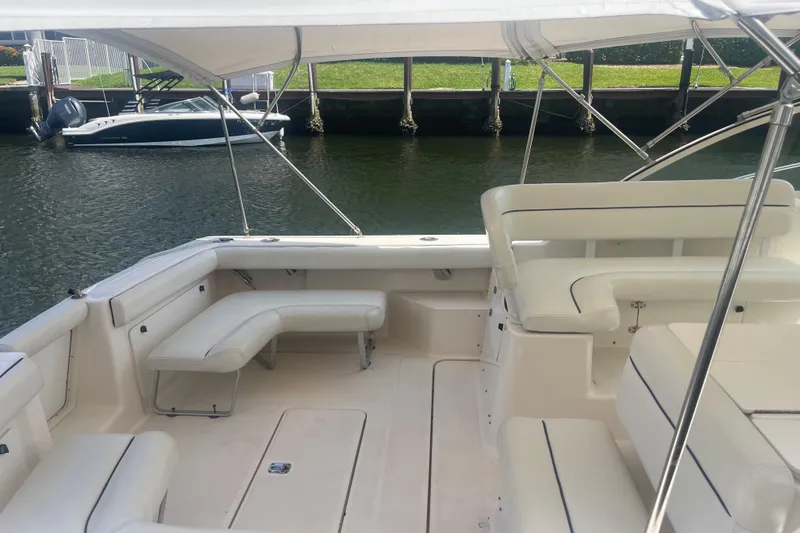 Slide: The Image of 2001 Tiara Yachts 2900 Coronet interior with white seating and canopy, docked by water. - 21