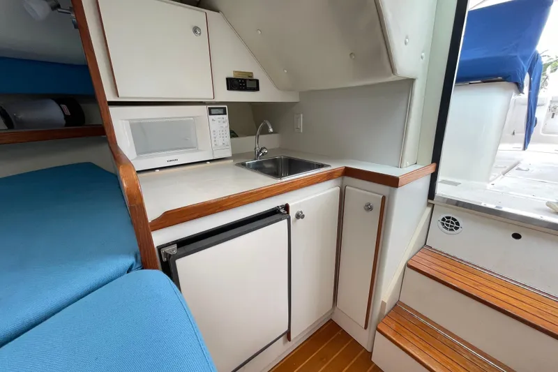 Slide: The Image of 2001 Tiara Yachts 2900 Coronet interior with kitchenette, microwave, sink, and seating area. - 46