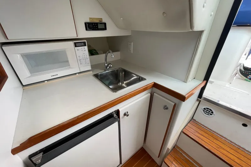 Slide: The Image of Compact galley in 2001 Tiara Yachts 2900 Coronet with microwave, sink, and storage cabinets. - 47