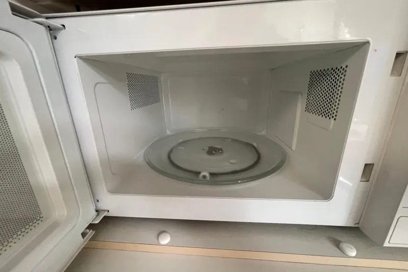 Slide: The Image of An open microwave oven with a clean interior and glass turntable. - 51