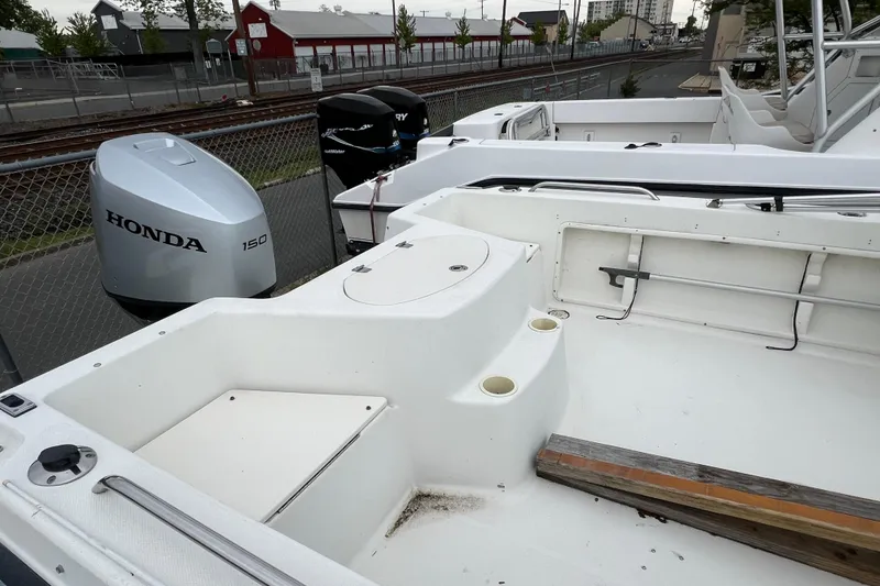Slide: The Image of 2004 Hydra-Sports Lightning 202 DC boat with Honda 150 outboard motor, docked near railway. - 5