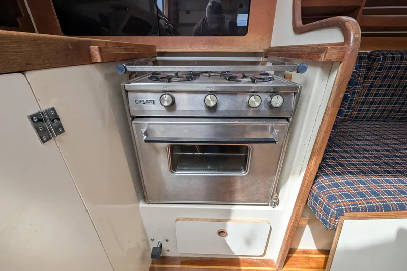 Slide: The Image of Compact kitchen area in a 1982 Pearson 323 sailboat with a stainless steel stove. - 14