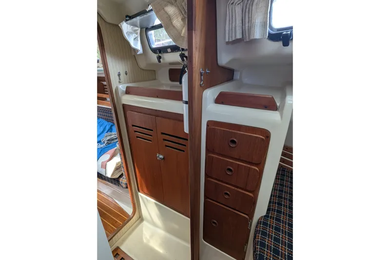 Slide: The Image of Interior of 1982 Pearson 323 sailboat with wooden cabinets and cozy seating area. - 16