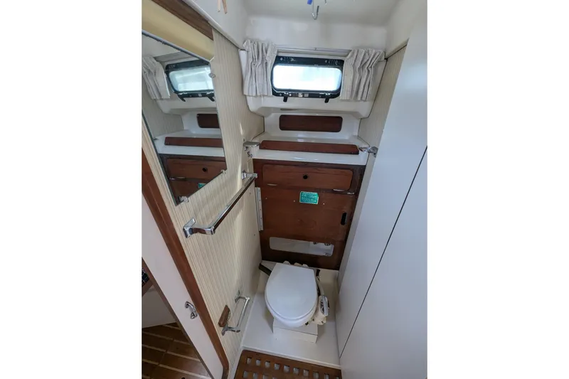 Slide: The Image of Compact bathroom interior of 1982 Pearson 323 sailboat with wooden accents and porthole window. - 19