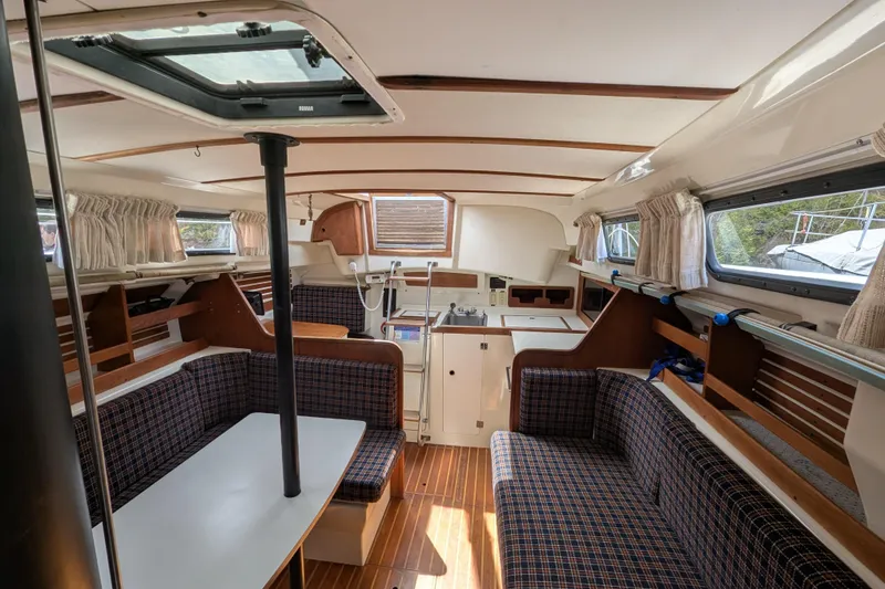 Slide: The Image of Interior of a 1982 Pearson 323 sailboat with seating, table, and kitchenette. - 2