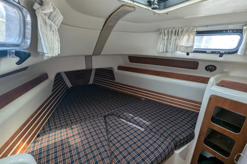 Slide: The Image of Interior cabin of a 1982 Pearson 323 sailboat with plaid cushions and wooden accents. - 21