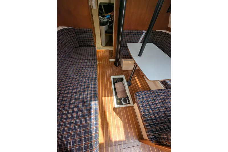 Slide: The Image of Interior of 1982 Pearson 323 sailboat with plaid seating and wooden flooring. - 27