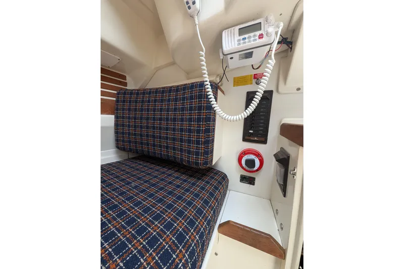 Slide: The Image of Interior of 1982 Pearson 323 sailboat with plaid seating and communication equipment. - 29