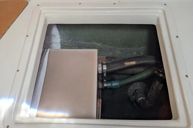 Slide: The Image of Access hatch of a 1982 Pearson 323 sailboat showing plumbing and hoses. - 31