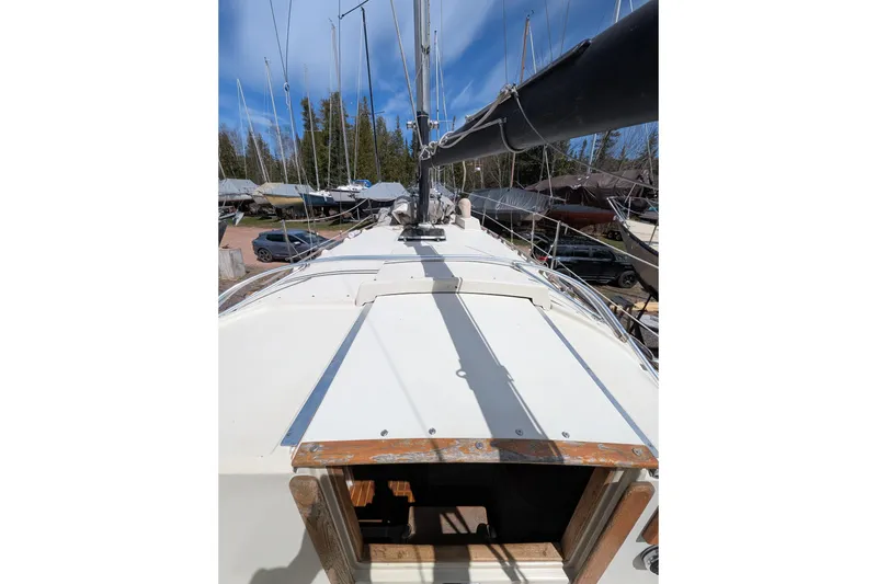 Slide: The Image of 1982 Pearson 323 sailboat deck view with mast, in a boatyard setting. - 36