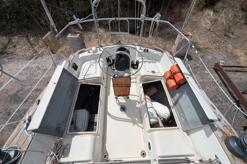 Slide: The Image of Cockpit of 1982 Pearson 323 sailboat with steering wheel and storage compartments. - 38