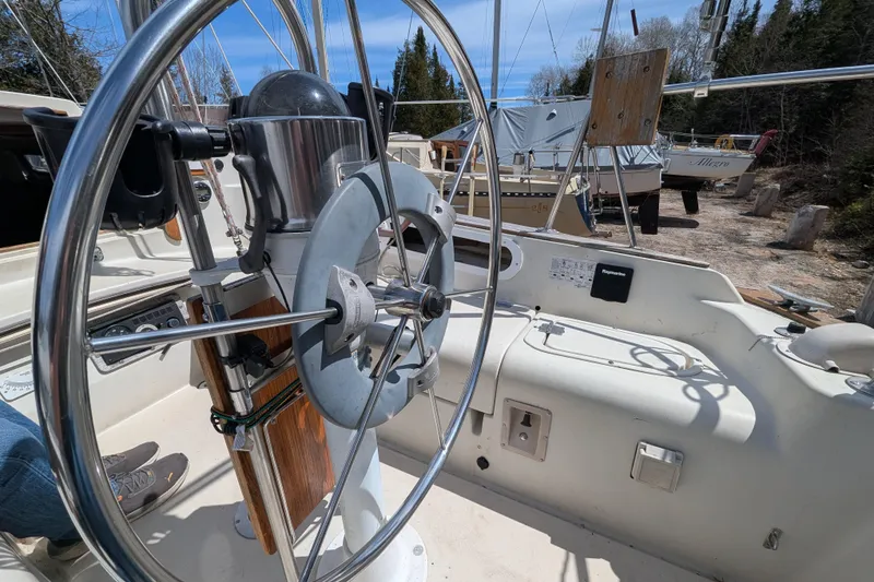 Slide: The Image of Cockpit view of a 1982 Pearson 323 sailboat with steering wheel and navigation instruments. - 45