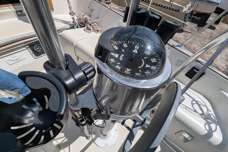 Slide: The Image of Cockpit of 1982 Pearson 323 sailboat featuring a compass and steering wheel. - 46