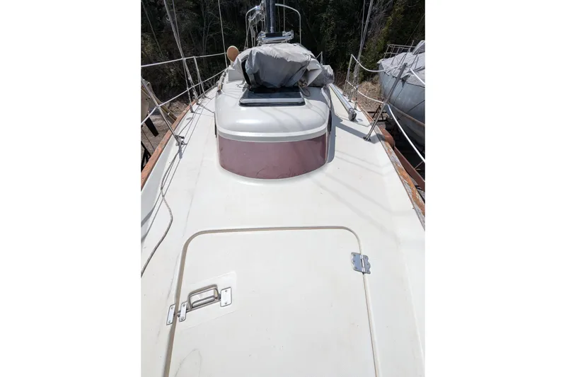 Slide: The Image of 1982 Pearson 323 sailboat deck with hatch and rigging, docked outdoors. - 48