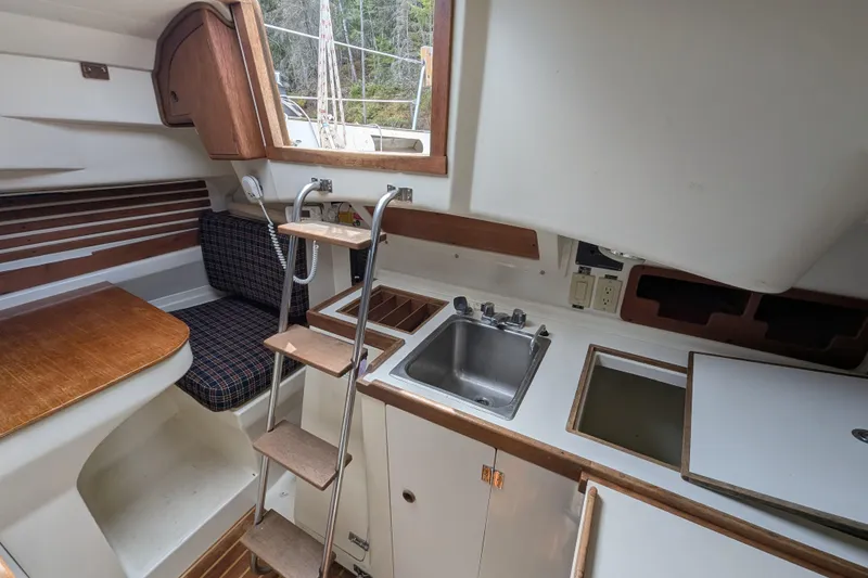 Slide: The Image of Interior of a 1982 Pearson 323 sailboat featuring a compact kitchen and seating area. - 5
