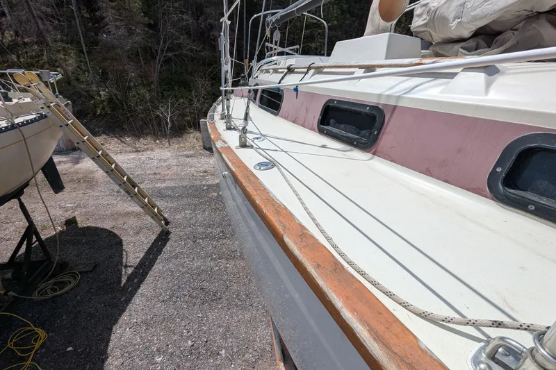 Slide: The Image of 1982 Pearson 323 sailboat on land, showing deck and rigging details. - 50