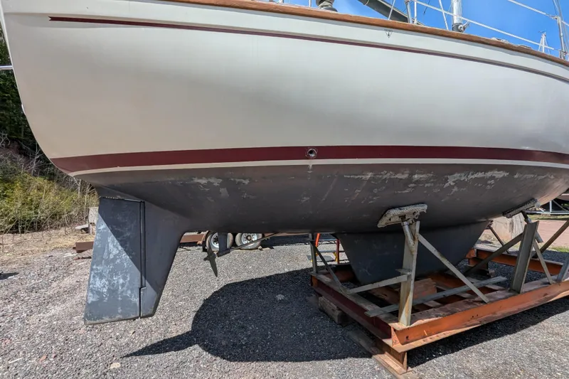 Slide: The Image of 1982 Pearson 323 sailboat on dry dock, showing hull and keel. - 54