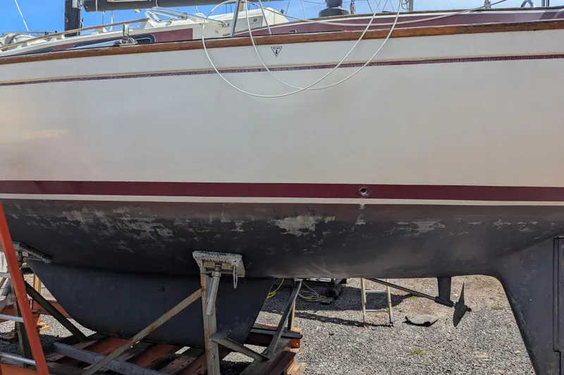 Slide: The Image of 1982 Pearson 323 sailboat on dry dock, showing hull and keel details. - 55