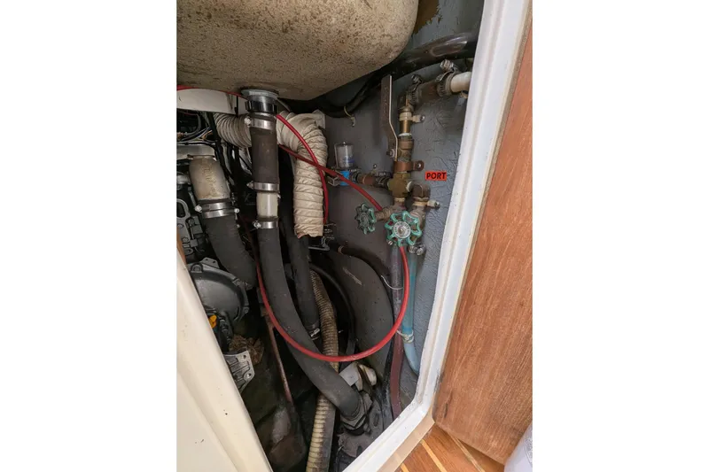 Slide: The Image of Engine compartment of a 1982 Pearson 323 sailboat, showing hoses and valves. - 58