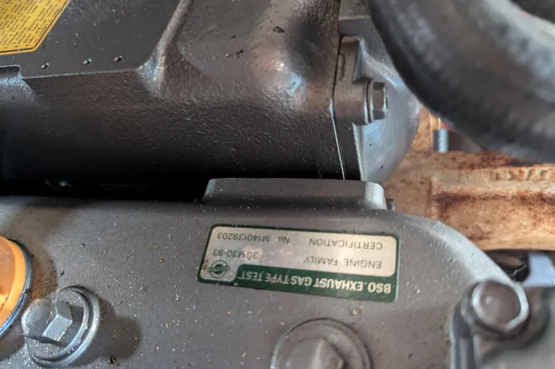 Slide: The Image of Close-up of a 1982 Pearson 323 engine component with certification label. - 59