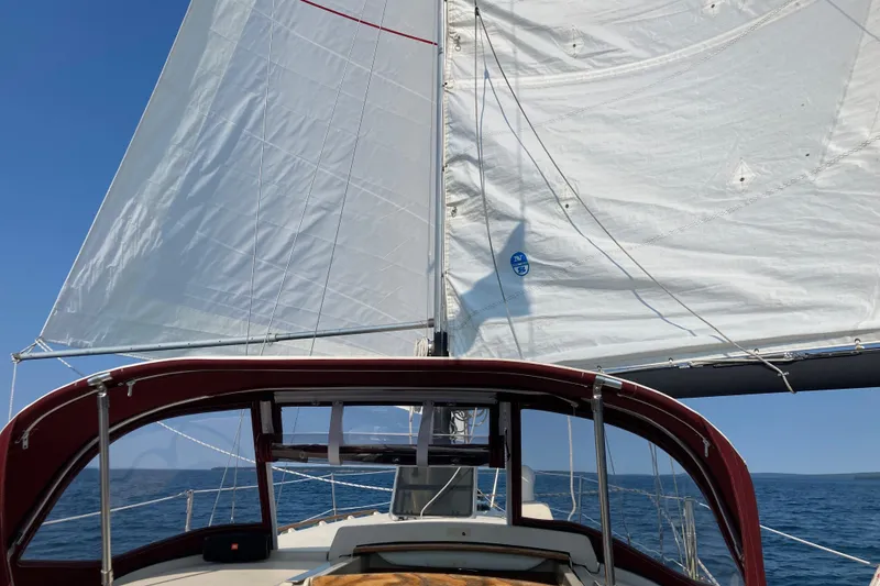 Slide: The Image of Sailing on a 1982 Pearson 323 yacht with white sails against a clear blue sky. - 61