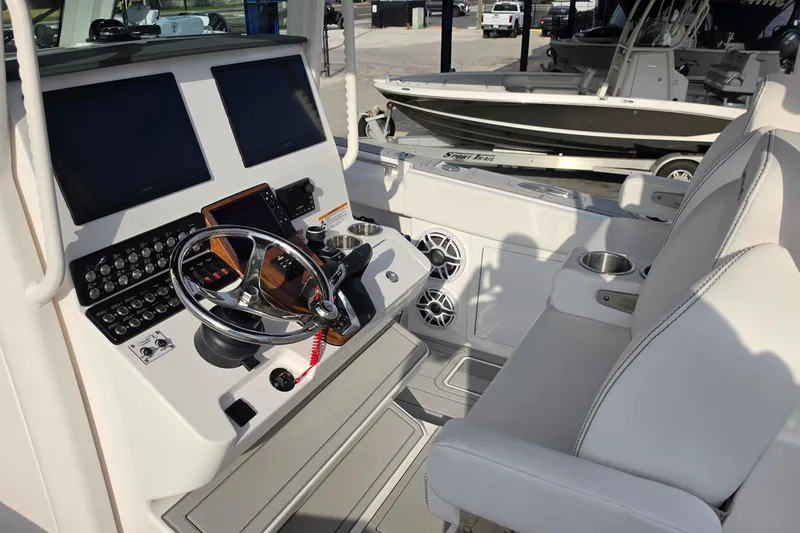 Slide: The Image of 2025 Caymas 34 CT boat cockpit with dual screens and modern steering controls. - 15