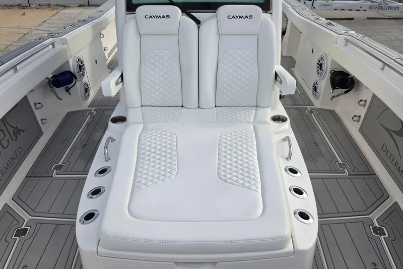 Slide: The Image of 2025 Caymas 34 CT boat interior with white cushioned seating and cup holders. - 27