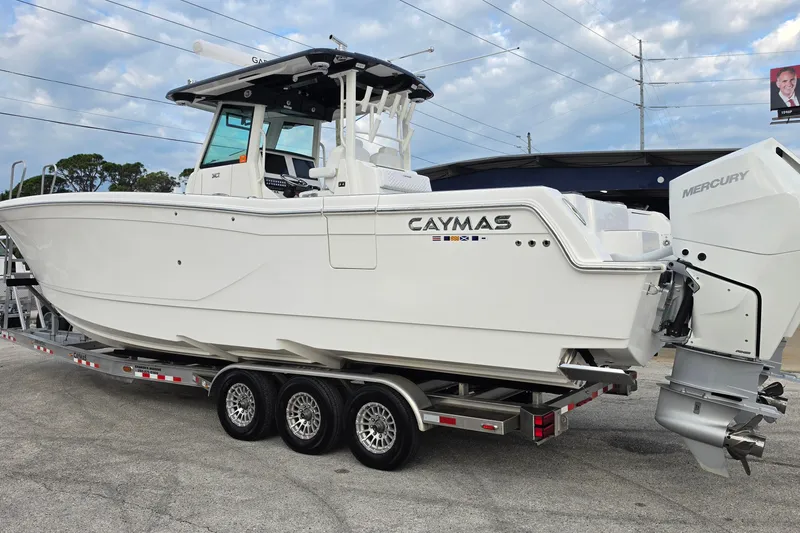 Slide: The Image of 2025 Caymas 34 CT boat on trailer with Mercury engine, parked outdoors. - 4