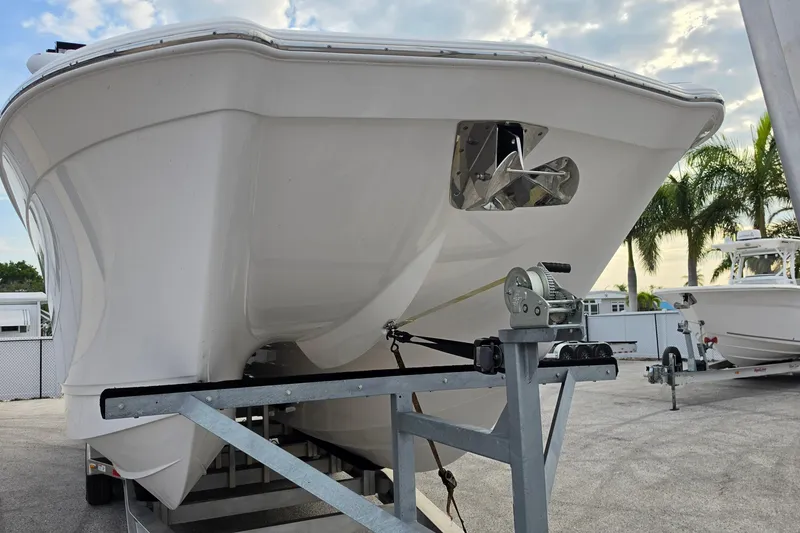 Slide: The Image of 2025 Caymas 34 CT boat on trailer, parked outdoors under a cloudy sky. - 9