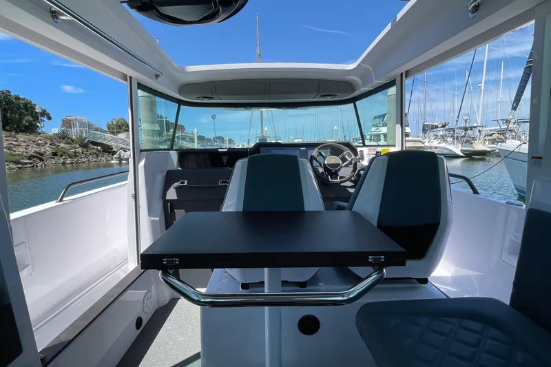 Slide: The Image of Interior of 2023 Axopar 37 XC Cross Cabin with table and seating, docked at marina. - 13