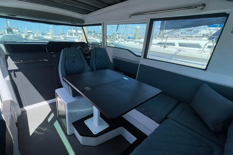 Slide: The Image of Interior of 2023 Axopar 37 XC Cross Cabin with seating and table, docked at marina. - 14