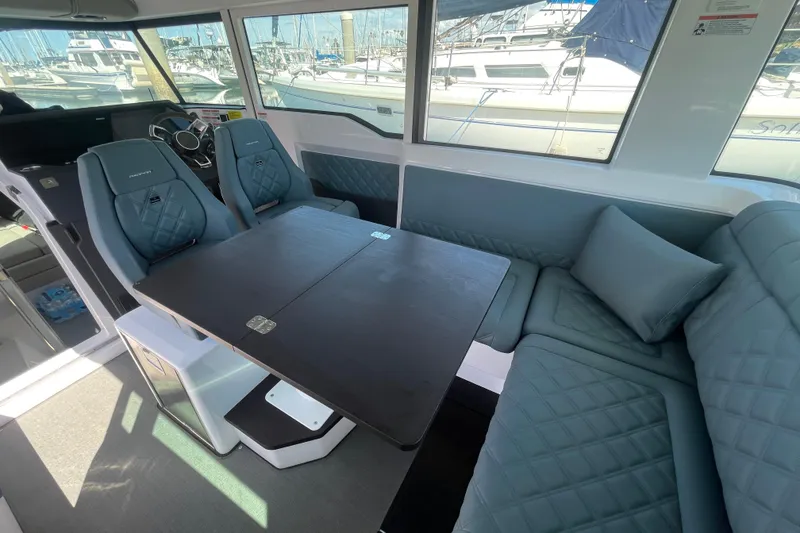 Slide: The Image of Interior of 2023 Axopar 37 XC Cross Cabin with seating and table, docked at marina. - 15