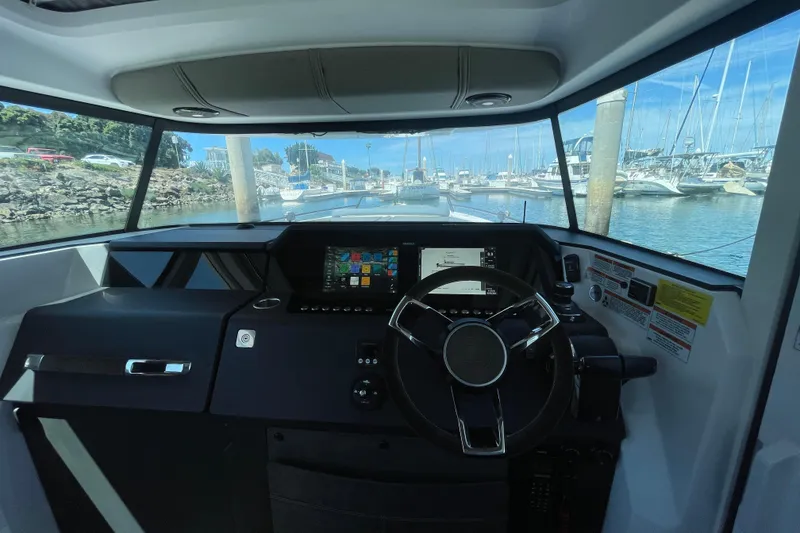 Slide: The Image of Interior view of 2023 Axopar 37 XC Cross Cabin boat cockpit with steering wheel and controls. - 21