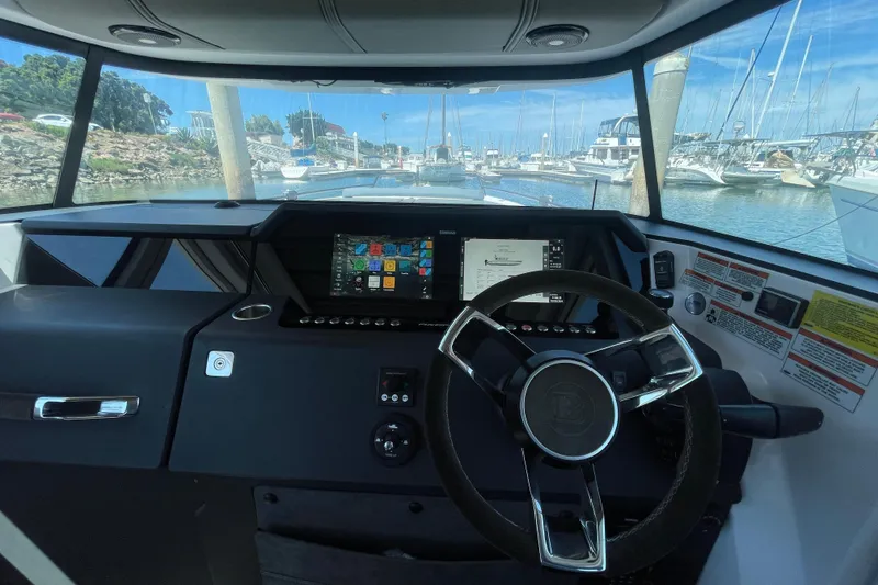 Slide: The Image of Interior view of 2023 Axopar 37 XC Cross Cabin boat cockpit with steering wheel and navigation display. - 22