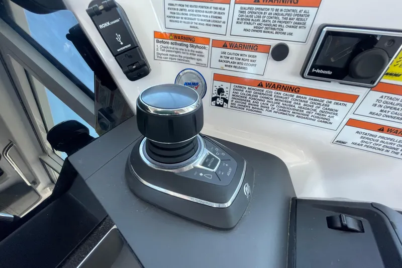 Slide: The Image of Control panel of 2023 Axopar 37 XC Cross Cabin with joystick and warning labels. - 25