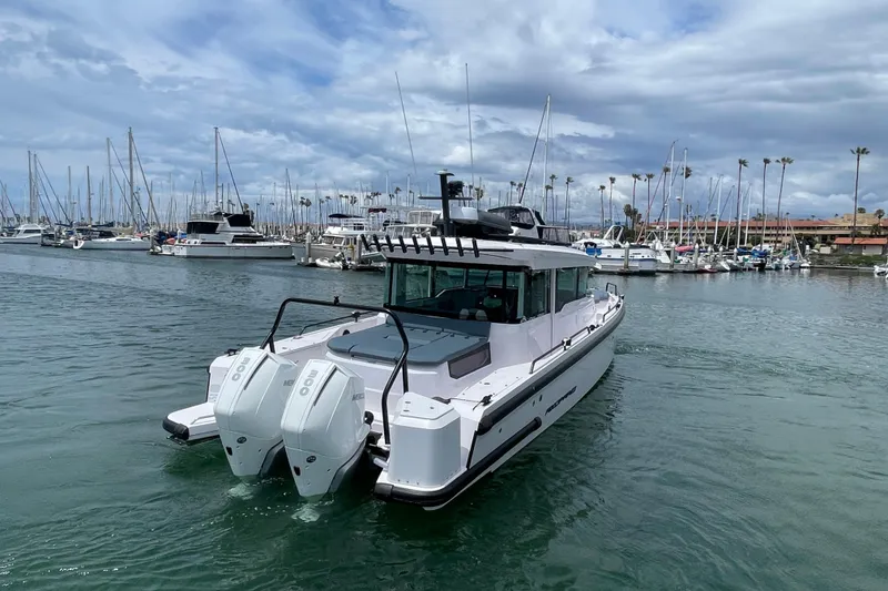 Slide: The Image of 2023 Axopar Brabus 37 XC Cross Cabin in harbor, featuring twin engines. - 4