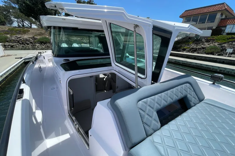 Slide: The Image of 2023 Axopar 37 XC Cross Cabin boat with open cabin door and cushioned seating. - 43