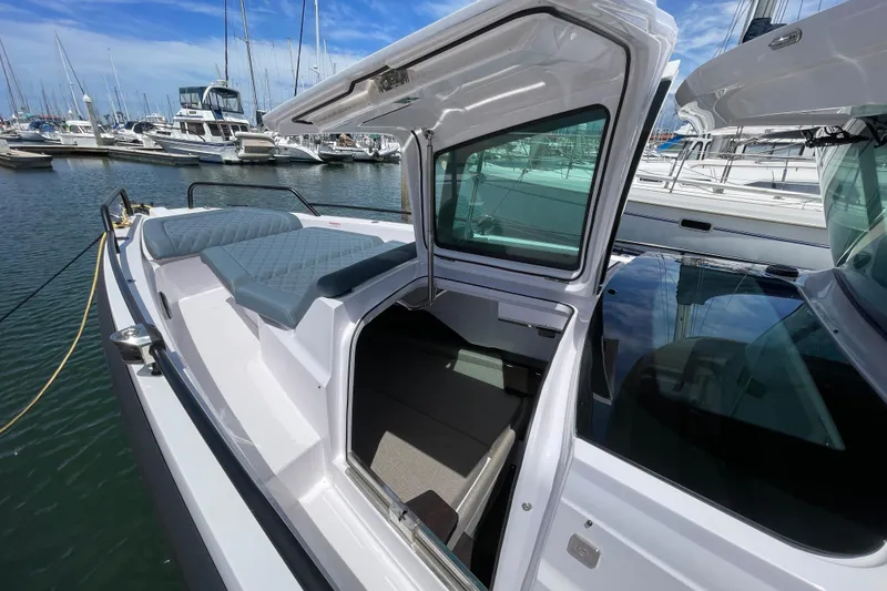 Slide: The Image of 2023 Axopar 37 XC Cross Cabin boat with open cabin door, docked at marina. - 44