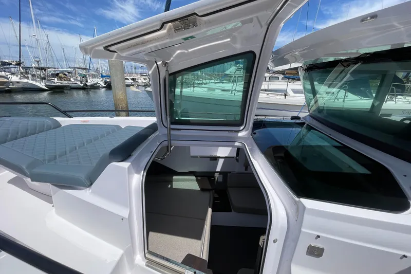 Slide: The Image of 2023 Axopar 37 XC Cross Cabin boat interior with open hatch, docked at marina. - 45