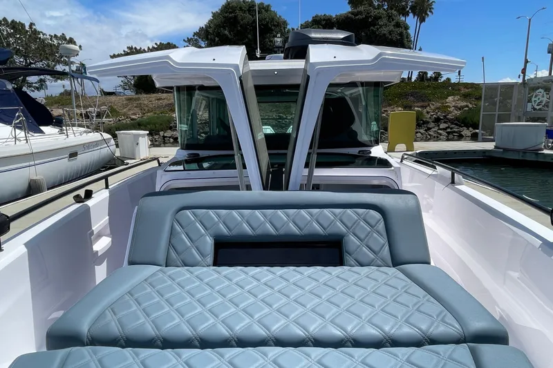 Slide: The Image of 2023 Axopar 37 XC Cross Cabin with luxurious seating at a marina. - 46
