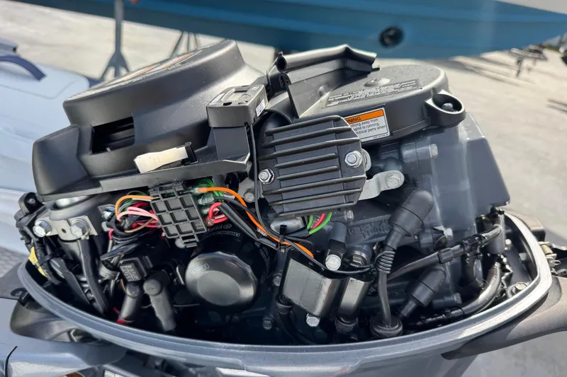 Slide: The Image of Close-up of a 2023 Highfield Ultralite 310 outboard motor with visible wiring and components. - 14