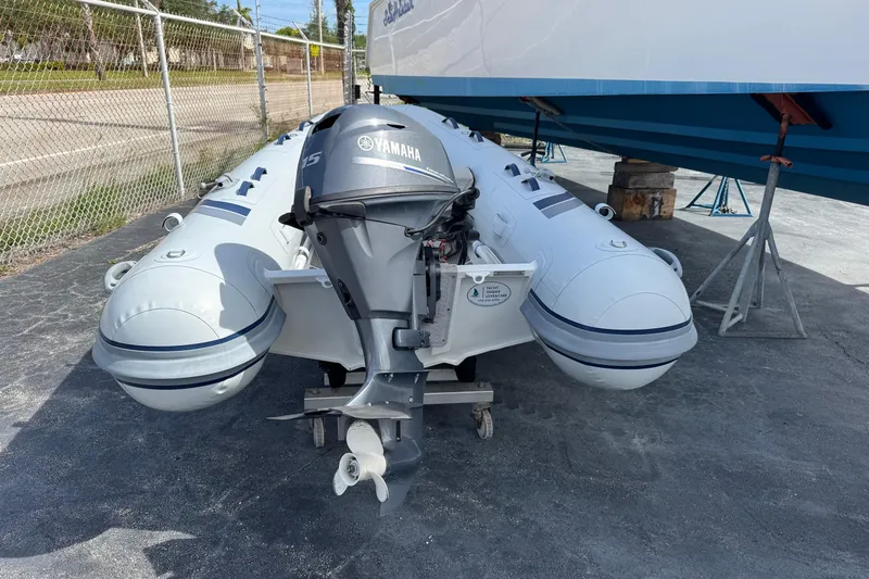 Slide: The Image of 2023 Highfield Ultralite 310 inflatable boat with Yamaha outboard motor, parked on pavement. - 3