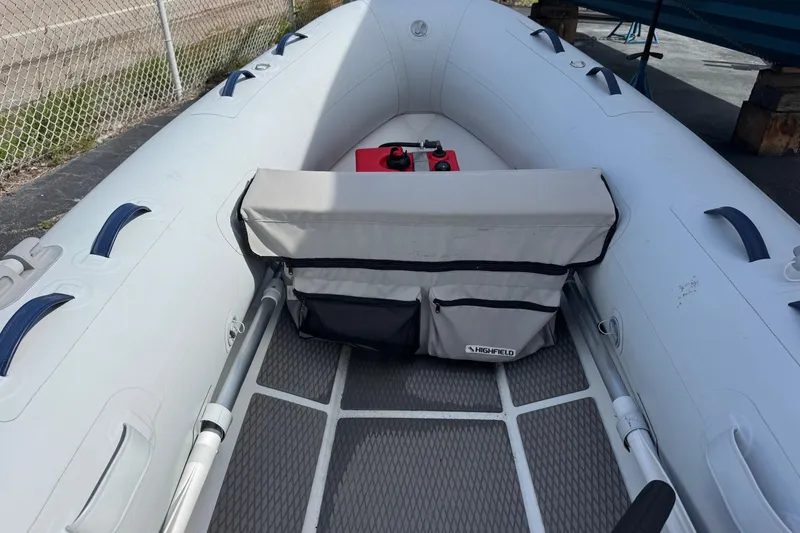Slide: The Image of 2023 Highfield Ultralite 310 inflatable boat with seating and storage, docked outdoors. - 4