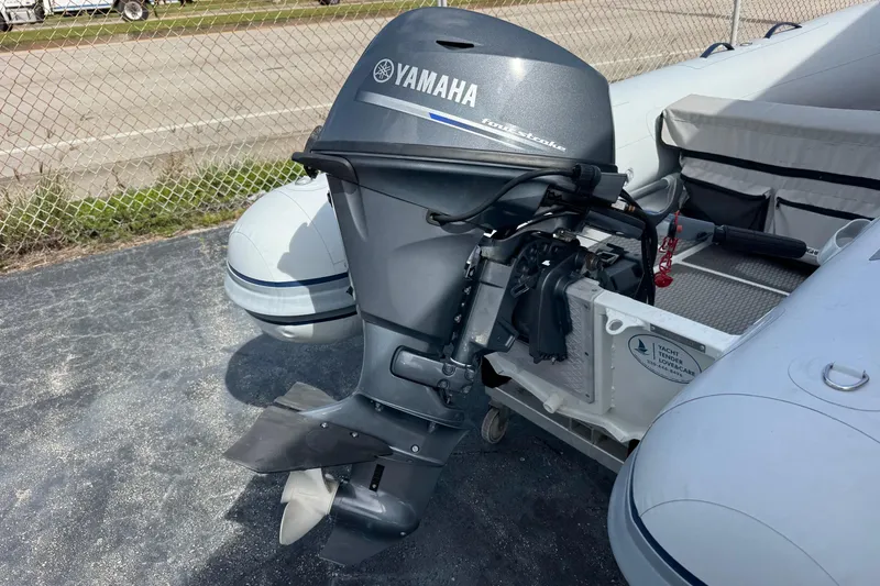 Slide: The Image of 2023 Highfield Ultralite 310 boat with Yamaha outboard motor, parked on pavement. - 9