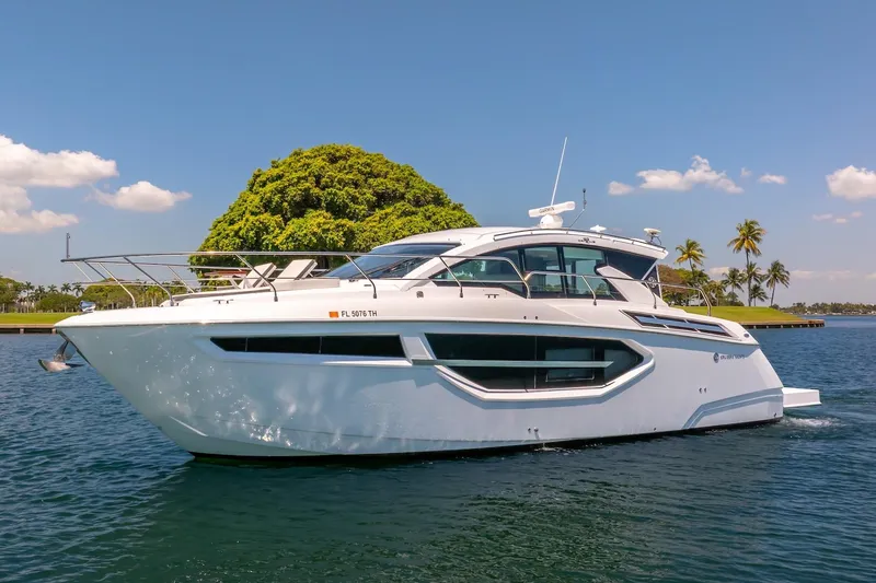 Slide: The Image of 2022 Cruisers Yachts 42 Cantius on serene water, clear sky, lush greenery backdrop. - 10