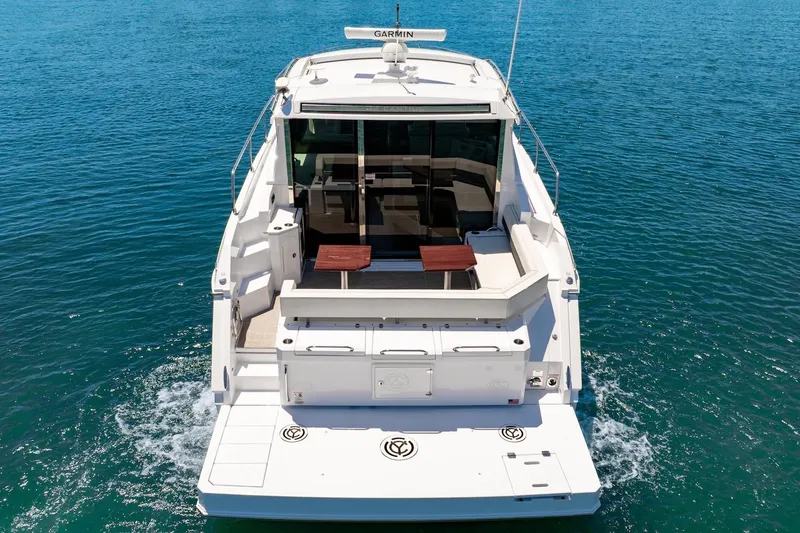 Slide: The Image of 2022 Cruisers Yachts 42 Cantius on open water, rear view showcasing deck and seating area. - 11