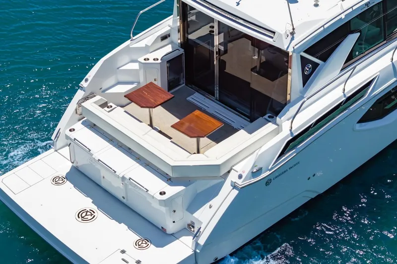 Slide: The Image of 2022 Cruisers Yachts 42 Cantius on blue water, featuring spacious deck and seating area. - 13