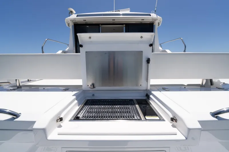 Slide: The Image of 2022 Cruisers Yachts 42 Cantius outdoor grill area under clear blue sky. - 14