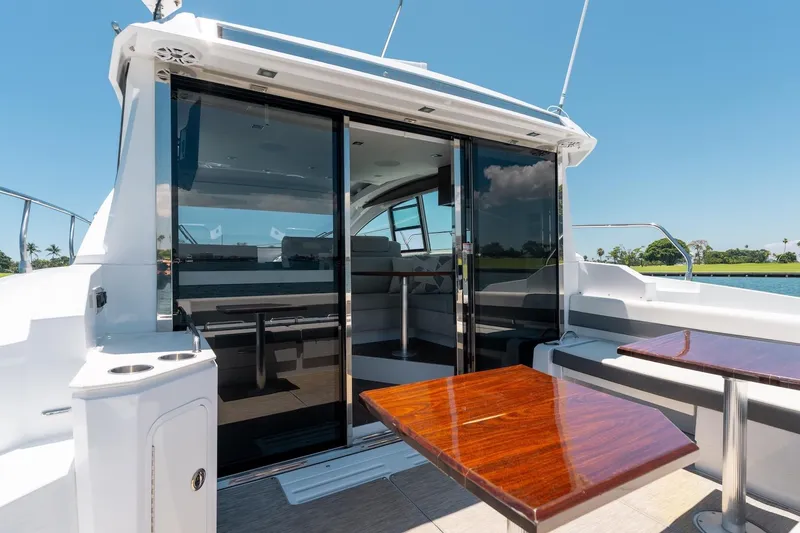 Slide: The Image of 2022 Cruisers Yachts 42 Cantius with sleek deck and glass doors, sunny day. - 26